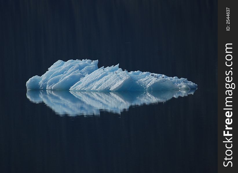 A small ice burg reflected in the pacific ocean. A small ice burg reflected in the pacific ocean