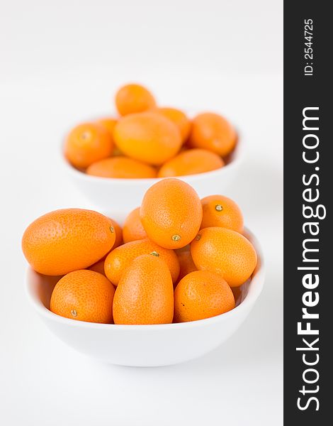 A bunch of Kumquats two small bowls