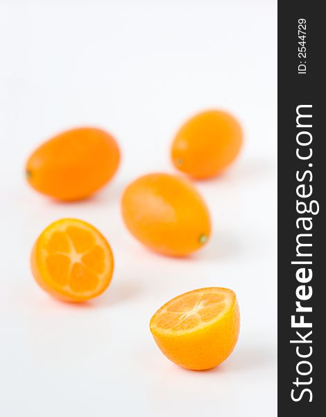 A bunch of Kumquats halved and on a white background