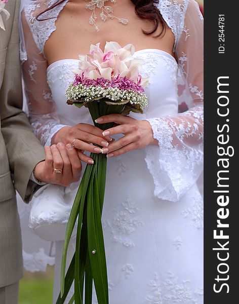 The groom with the bride and a bouquet close up. The groom with the bride and a bouquet close up