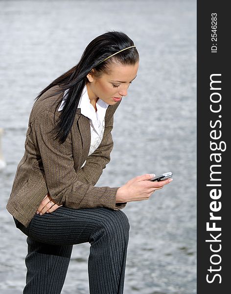 Young woman in business suit reading SMS message. Young woman in business suit reading SMS message