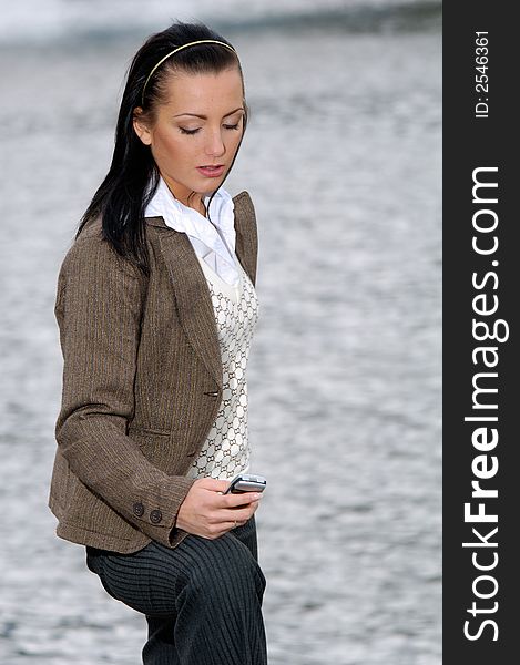 Young woman in business suit reading text message. Young woman in business suit reading text message