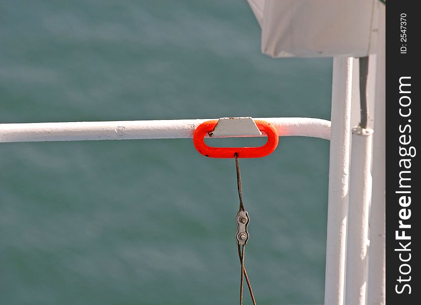 An orange handle attached to pulley cable on a ship