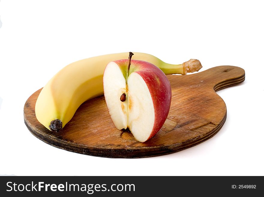 Apple and banana on chopping board isolated on white with shadow