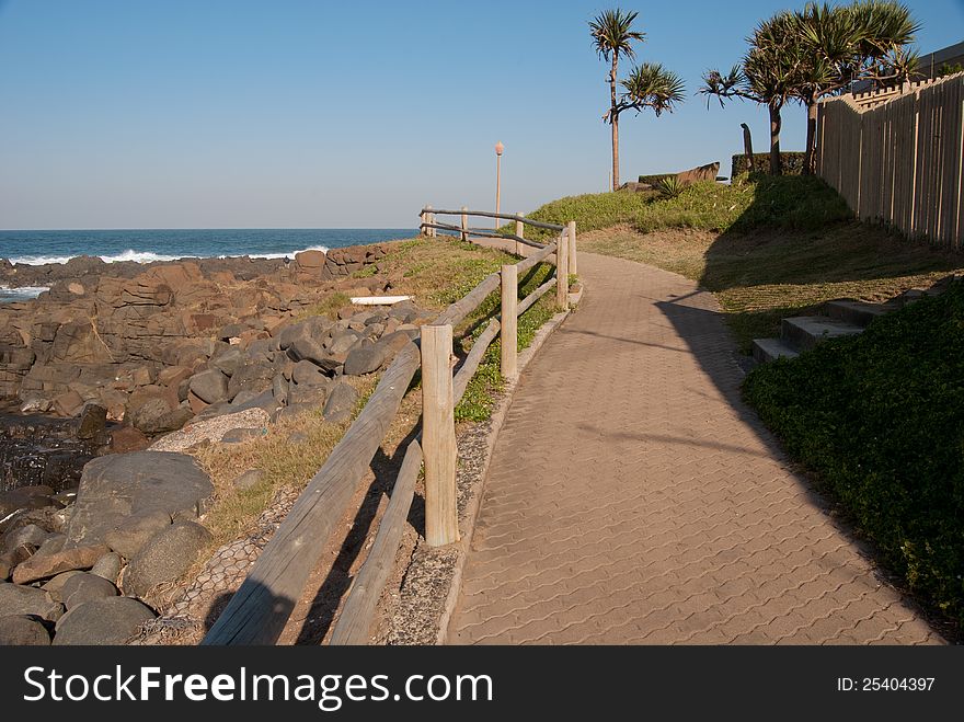 A pathway with wooden rail, running along the shore at Ballito, KwaZulu-Natal North Coast, South Africa. A pathway with wooden rail, running along the shore at Ballito, KwaZulu-Natal North Coast, South Africa.