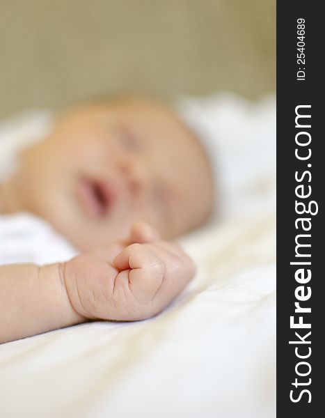 New born baby's hand with sleeping baby in background. New born baby's hand with sleeping baby in background