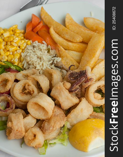 Fried calamari with vegetables on the plate