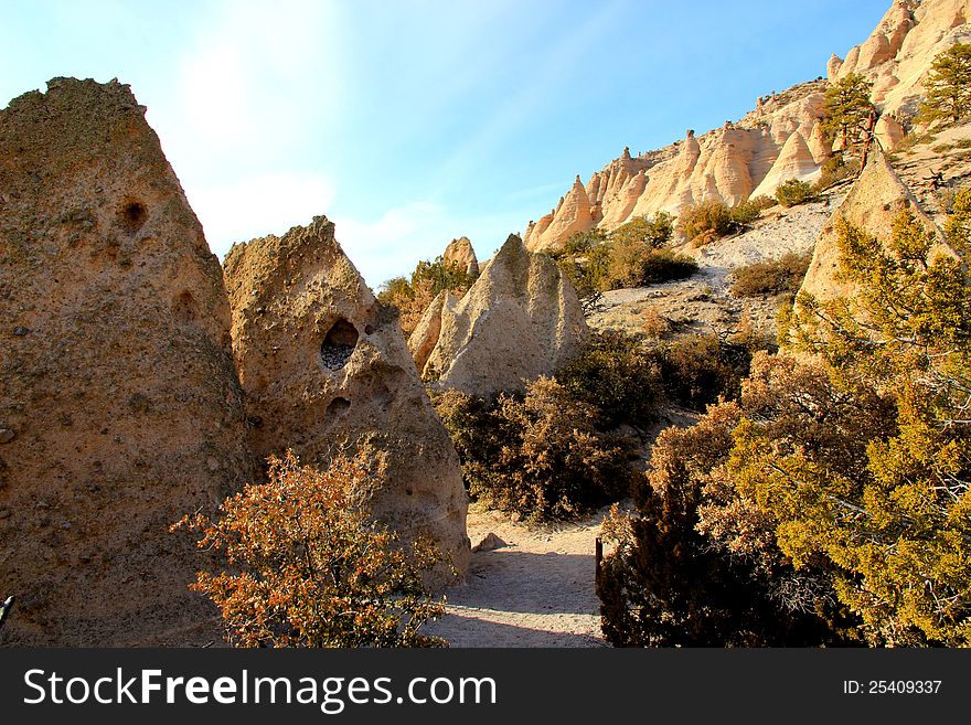 Rock formations in eroded hillside at tent rocks national monument.  Each tent is made of soft volcanic rock capped by a single hard rock.