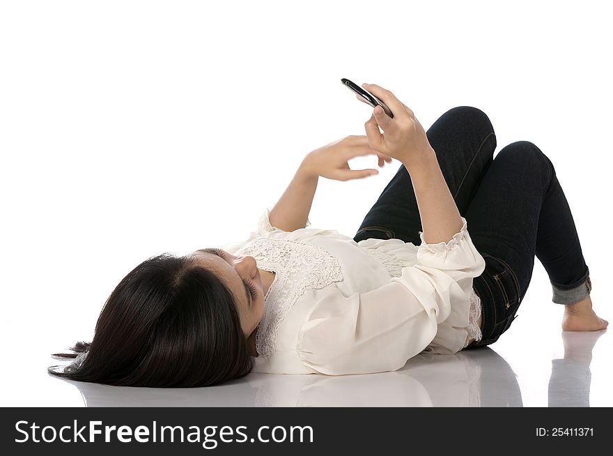 Asian woman texting while laying on the floor. Asian woman texting while laying on the floor