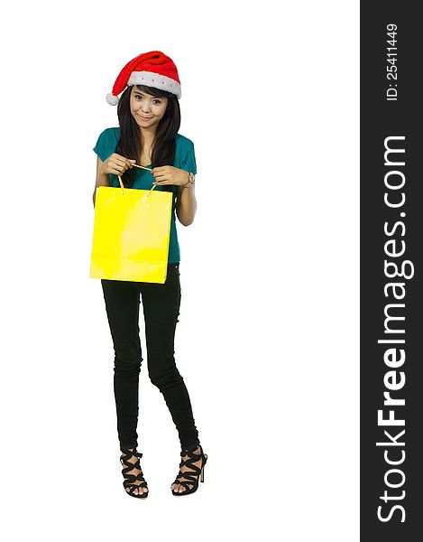 Asian woman wearing santa hat holding yellow shopping bag isolated over white background. Asian woman wearing santa hat holding yellow shopping bag isolated over white background