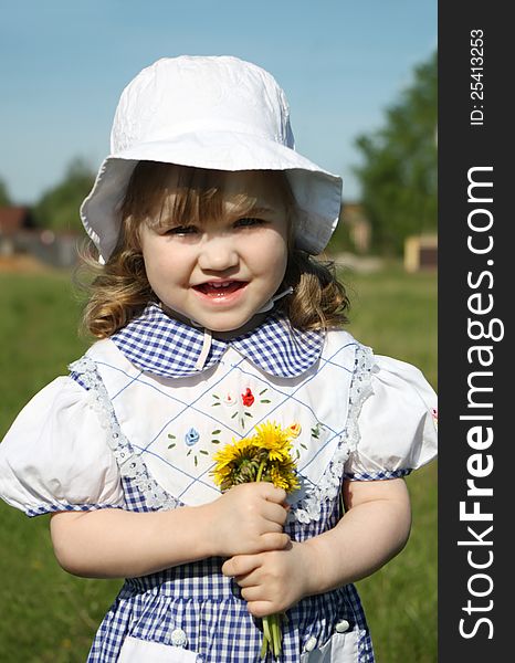 Beautiful Little Girl Holds Yellow Dandelions