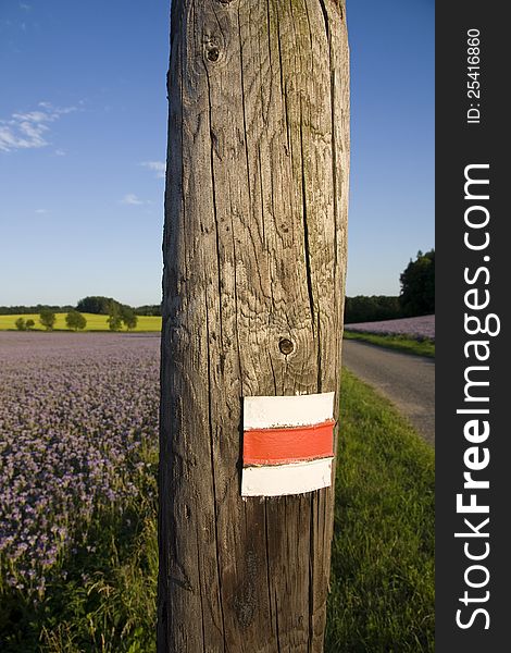 Red and white sign on a wooden pole, landmark in the landscape for tourists. Red and white sign on a wooden pole, landmark in the landscape for tourists