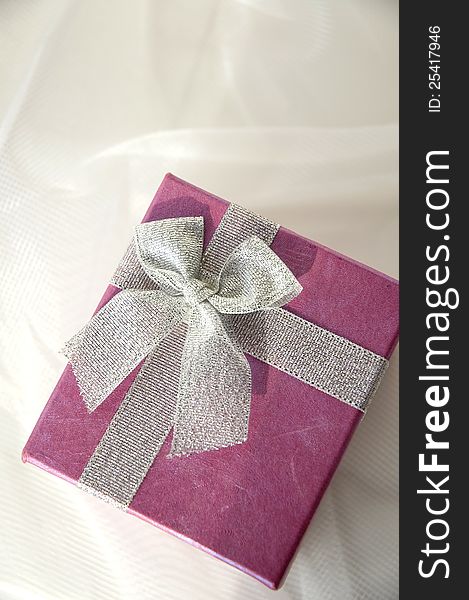 Top view of pink gift box with silver ribbon