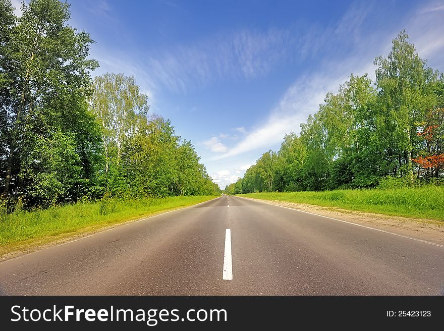 Smooth asphalt road surrounded by forest. Central Russia