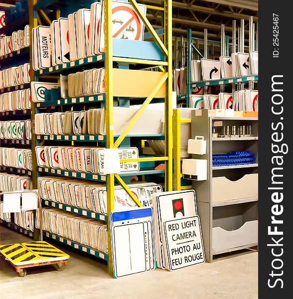 Public street road signs in storage on racks awaiting deployment.