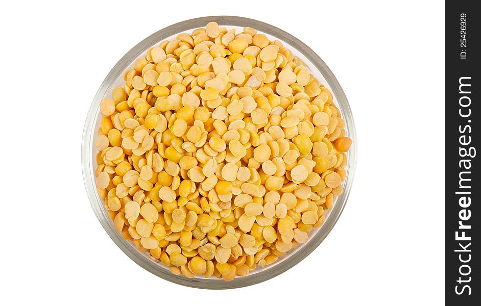 Yellow split peas in transparent glass bowl  over white
