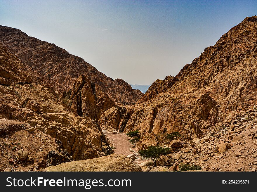 Picturesque road in the desert between the sandy mountains near the city of Aqaba in Jordan on the shore of the Red Sea