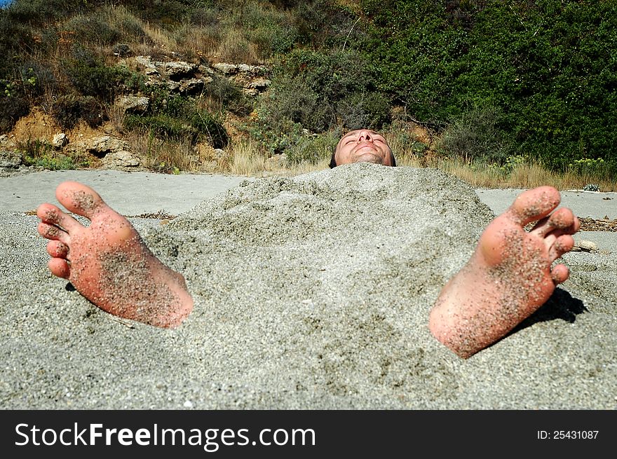 Man covered by sand on the beach