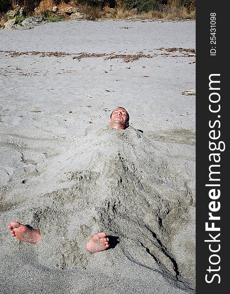 Man Covered By Sand On The Beach