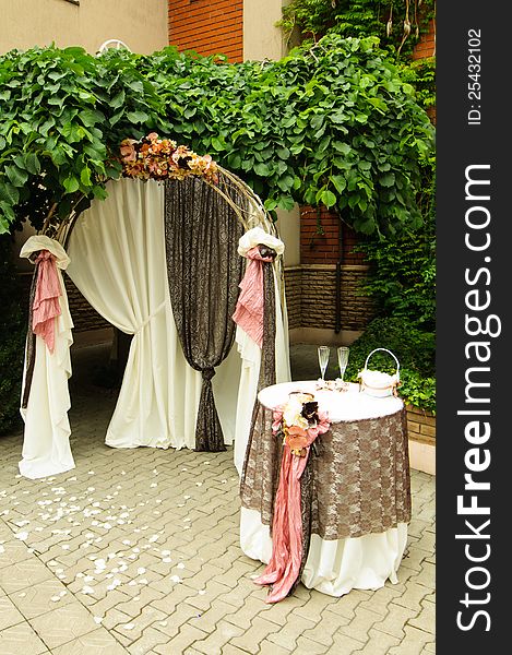 Outdoor wedding arch with table under grapewine