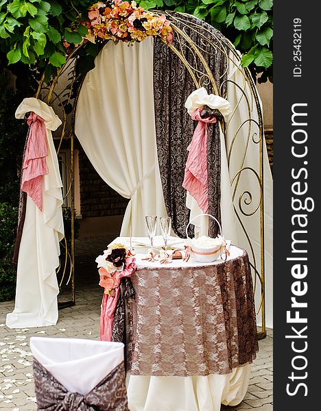 Outdoor wedding arch with table under grapewine