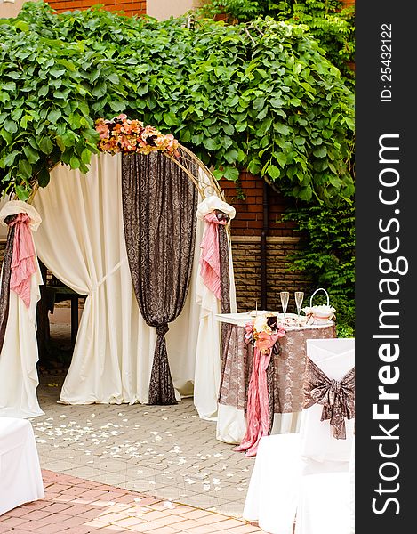 Outdoor wedding arch with table under grapewine