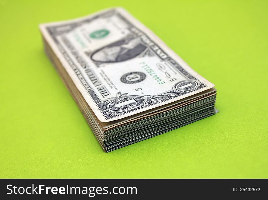 Stack of $1 bills over green background. Stack of $1 bills over green background