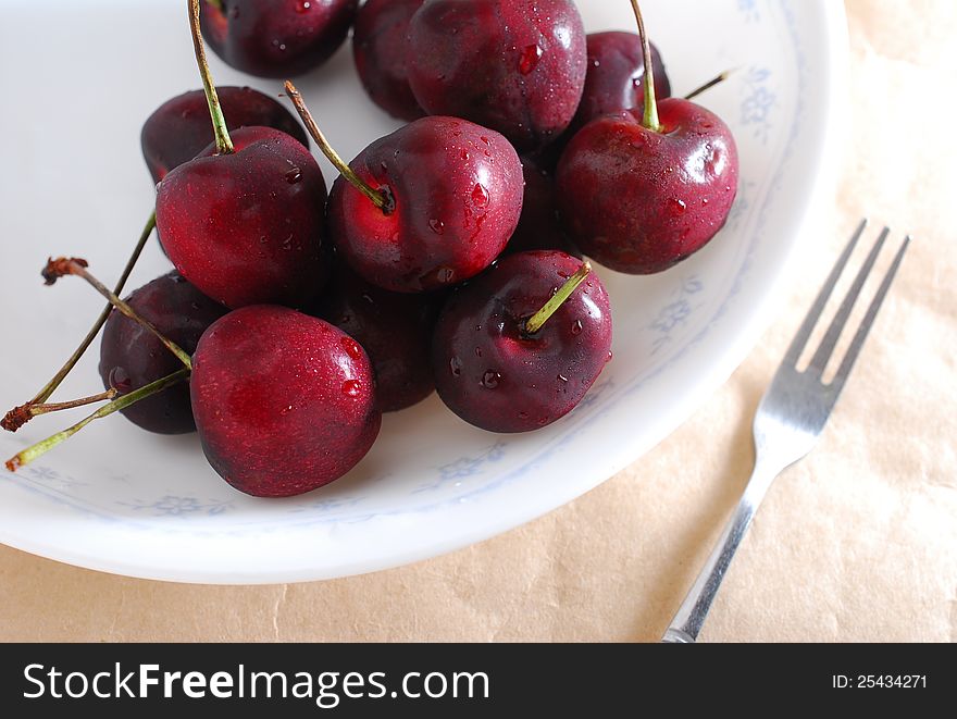 Many red cherry fruit with fork