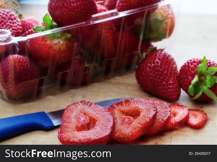 Whole and sliced ripe strawberries on cutting board. Whole and sliced ripe strawberries on cutting board