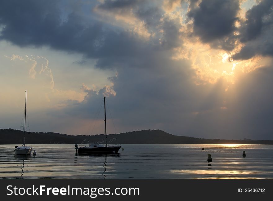 Dramatic cloudscape at sunset hours over lake waters