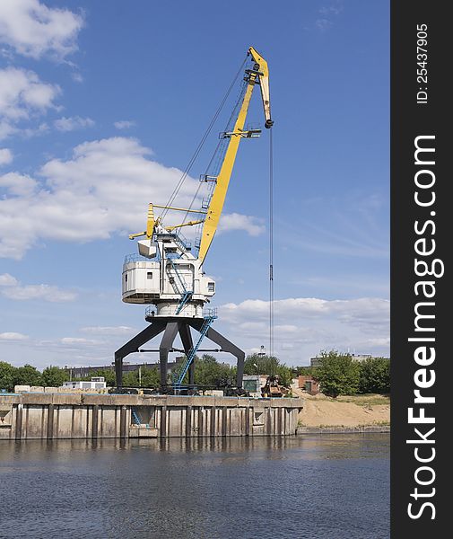 The old port crane on a river mooring. The old port crane on a river mooring.