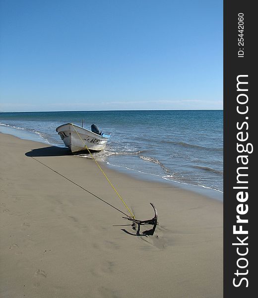 White motorboat anchored on beach in Mazatlan, Mexico. White motorboat anchored on beach in Mazatlan, Mexico