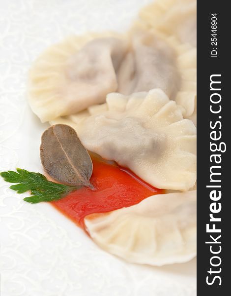 Closeup of a serving of boiled pelmeni in made from thin unleavened dough and a savoury meat filling. Closeup of a serving of boiled pelmeni in made from thin unleavened dough and a savoury meat filling