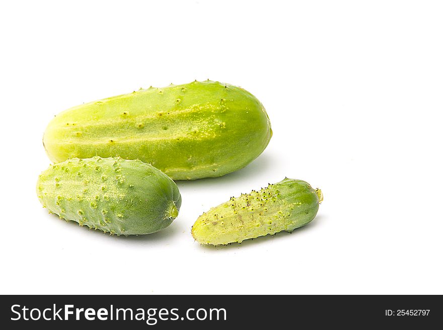 Three cucumbers of the different sizes lays on a white background. Three cucumbers of the different sizes lays on a white background