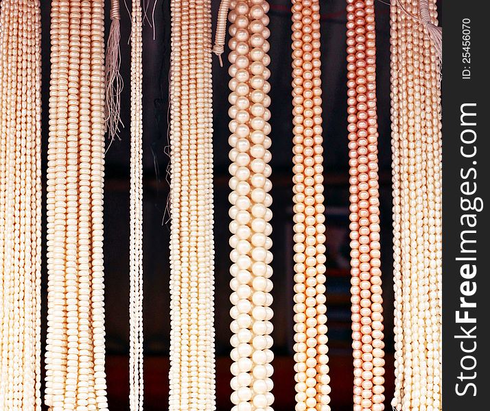 Colorful pearl beads hanging. Different sized pearls are there over dark background. Colorful pearl beads hanging. Different sized pearls are there over dark background