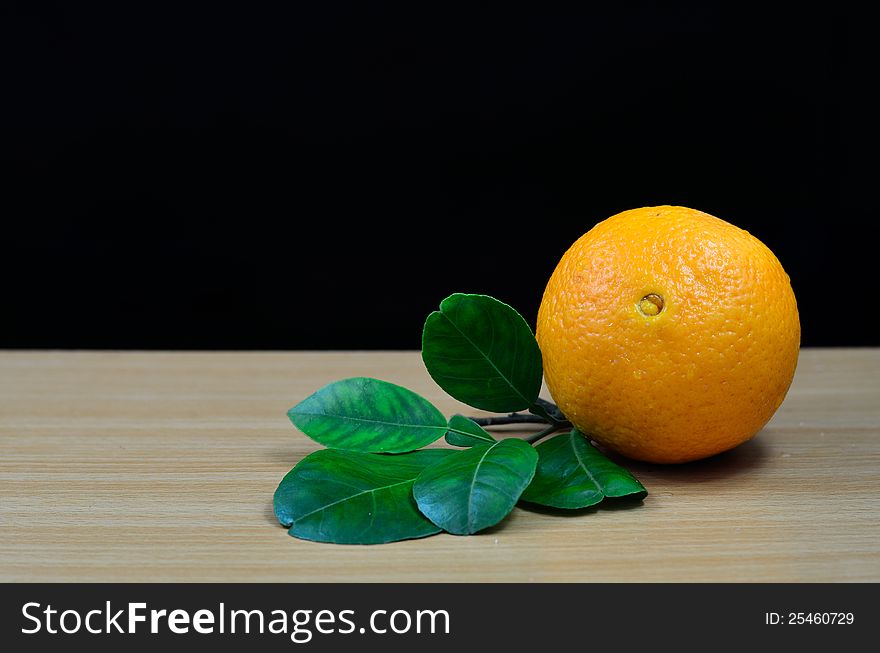 Orange on table with black background