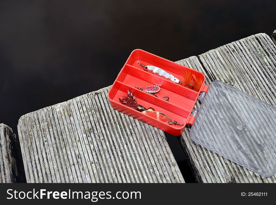 A fishing  Box on a bridge by the lake. A fishing  Box on a bridge by the lake