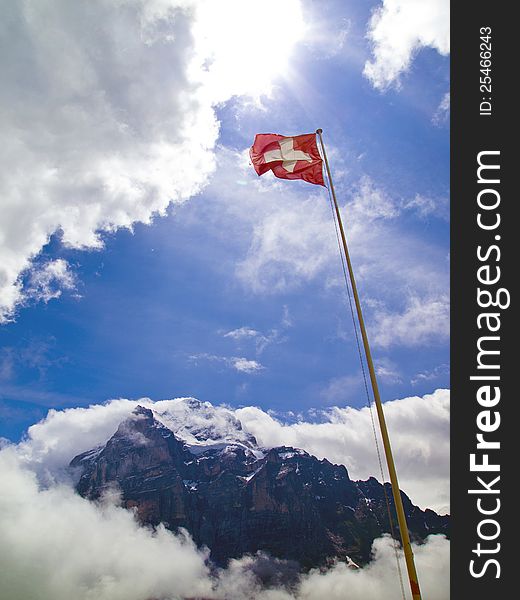 A national flag of Switzerland and Wetterhorn mountain. A national flag of Switzerland and Wetterhorn mountain