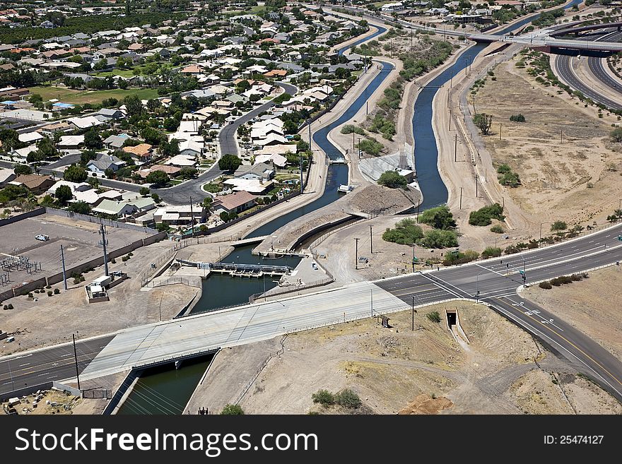 Irrigation canal cutting through suburban desert neighborhood