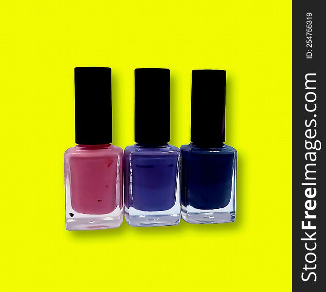 Three jars of nail polish isolated on a yallow background