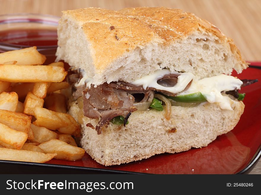 Closeup of a roast beef sandwich with french fries