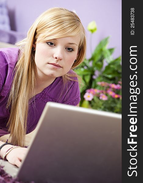 Pretty young woman using laptop at home