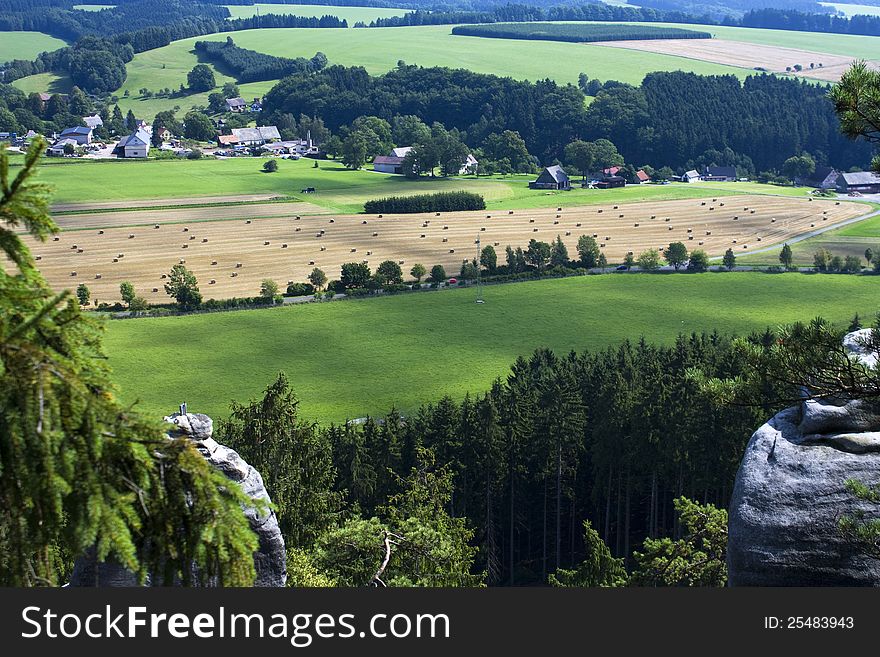 View of farm fields and countryside in the valley, landscape with forests, meadows and rocks. View of farm fields and countryside in the valley, landscape with forests, meadows and rocks