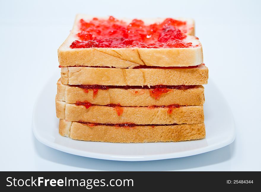 Layer bread with jam in the plate on white background. Layer bread with jam in the plate on white background