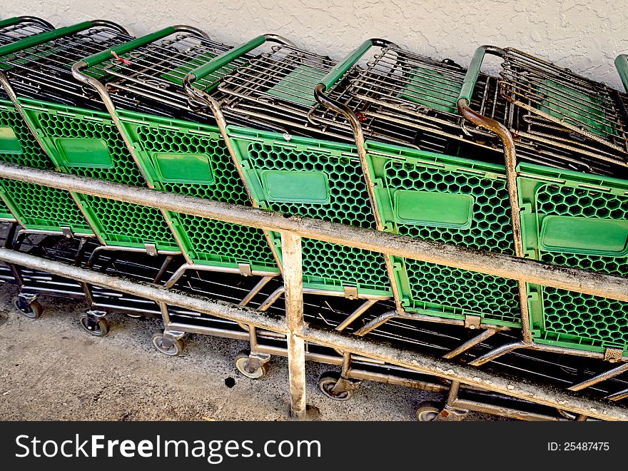 Green grocery shopping carts in a cart return. Green grocery shopping carts in a cart return