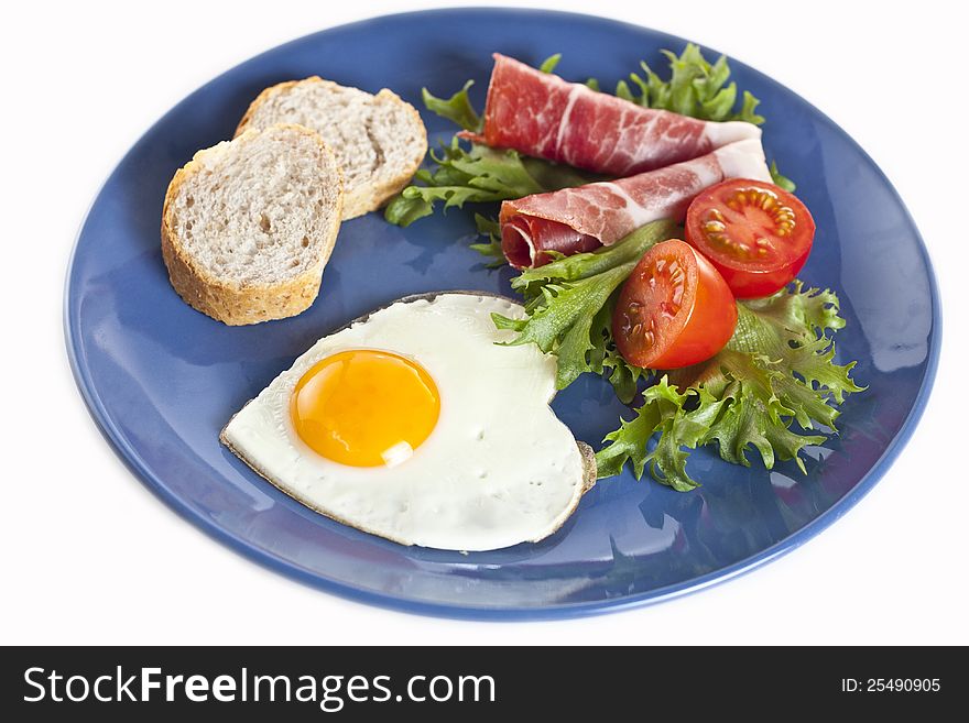 Breakfast plate of sunny side up, timatoes, bacon, eggs, bread, lettuce