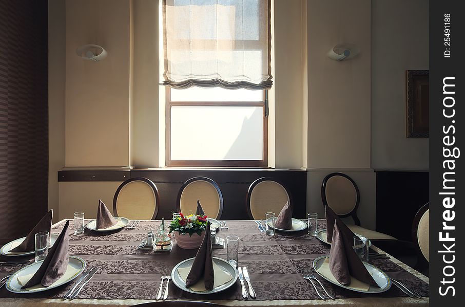 Served table in a hotel restaurant, near the window, during day time. Served table in a hotel restaurant, near the window, during day time.