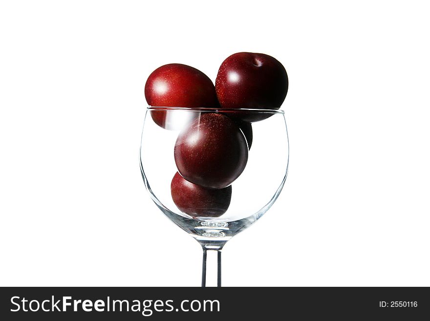 Red plums inside a cup. Red plums inside a cup
