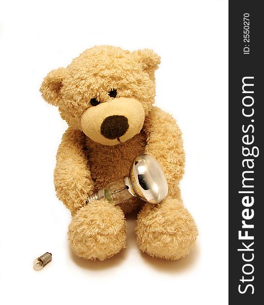 The  teddy-bear holding the bulb isolated in white. The  teddy-bear holding the bulb isolated in white