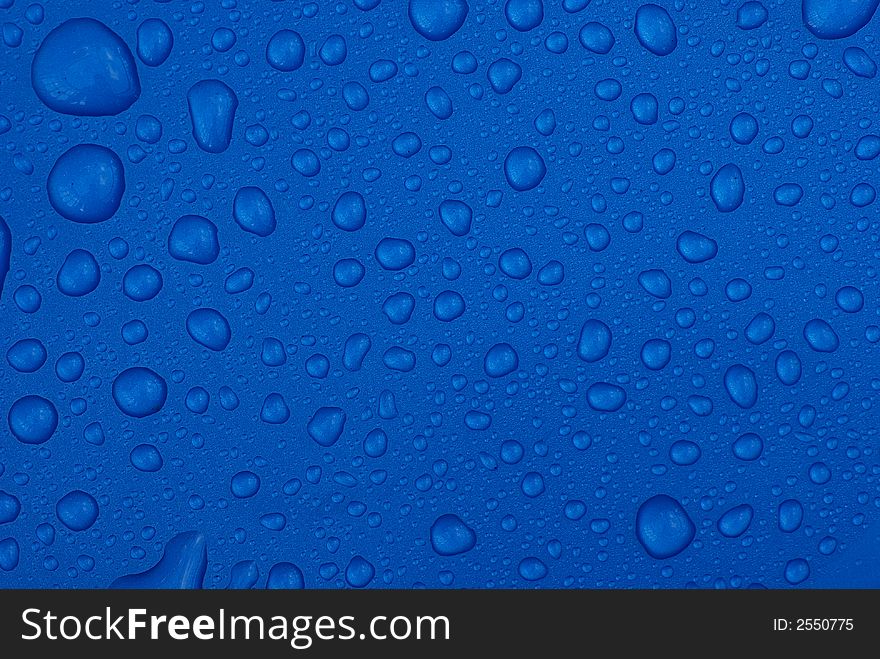 Raindrops on a metallic blue plastic surface. Raindrops on a metallic blue plastic surface